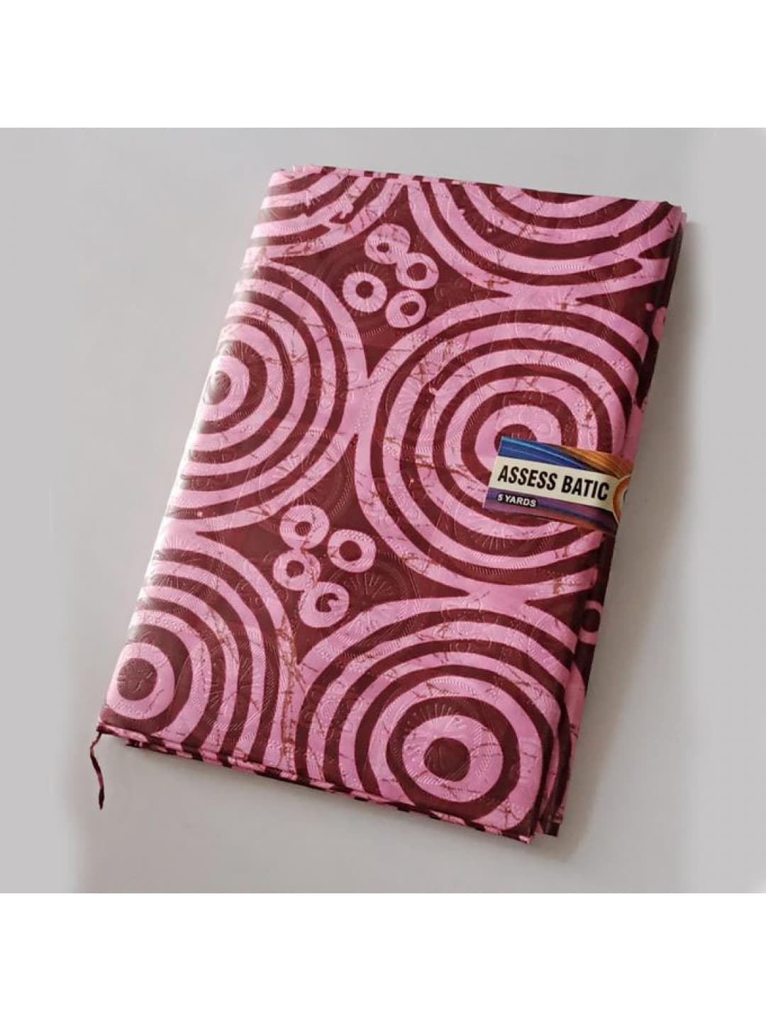 Folded Pure Adire Kampala fabric with pink rings on a wine ground