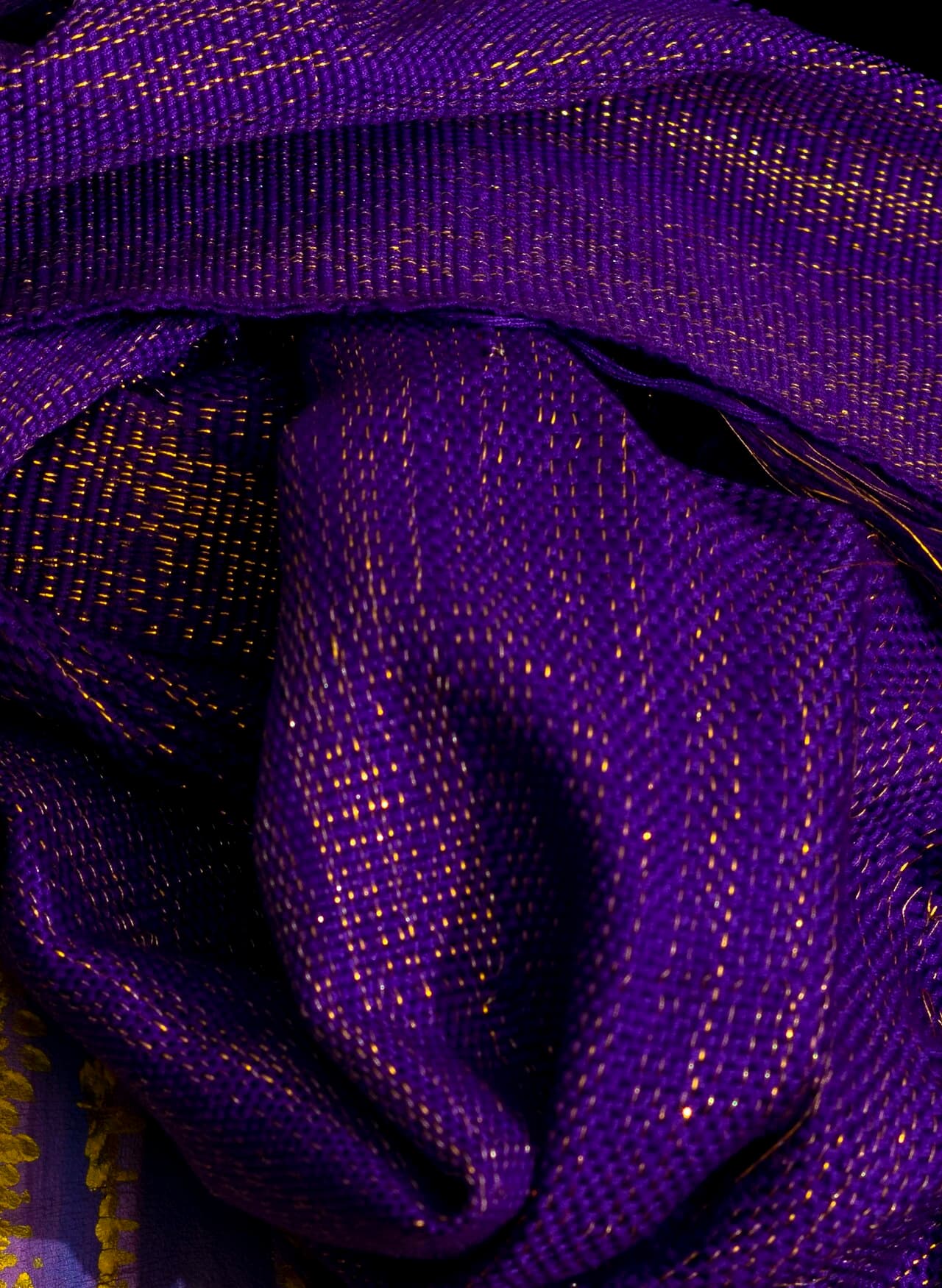 Close-up of royal purple Aso Oke woven with gold metallic thread